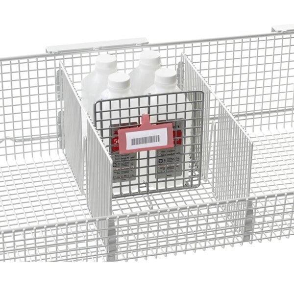 A white metal wire basket divider in a white wire basket with bottles inside.