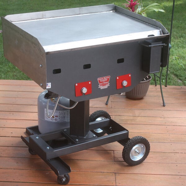 A R & V Works Cajun Bayou outdoor griddle on a deck with red handles.