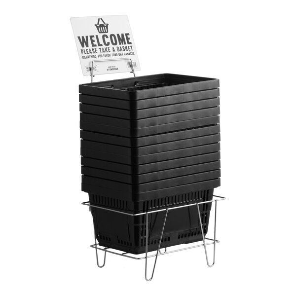 A stack of black plastic grocery market shopping baskets with a metal stand and a welcome sign.