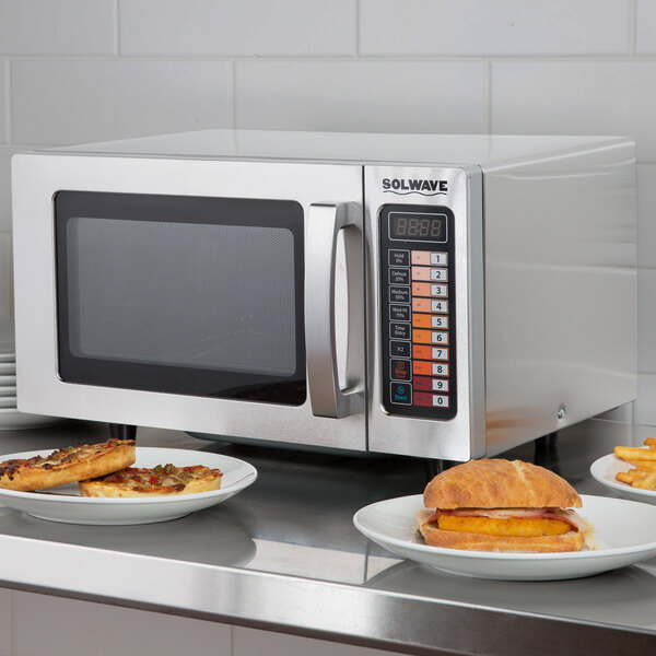 A Solwave microwave with food on plates on a counter in a hotel buffet.