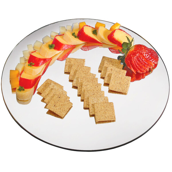 A Cal-Mil round mirror tray with cheese and apple slices on it.