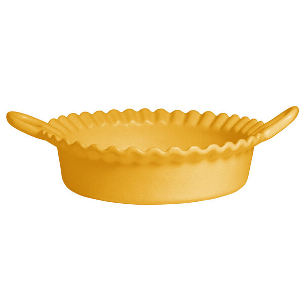 A yellow G.E.T. Enterprises deep Mexican cazuela bowl with a handle.