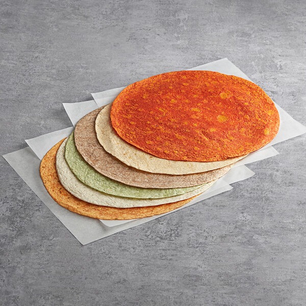 A stack of multi colored Father Sam's Bakery tortillas on a white surface.