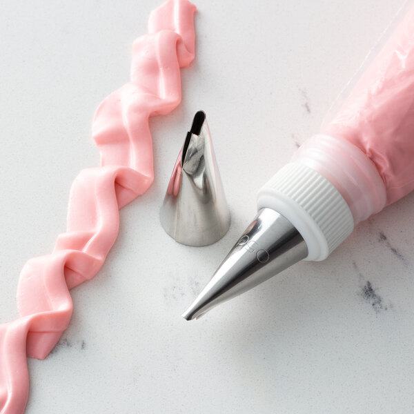 A metal Ateco ruffle piping tip attached to a pink pastry bag.