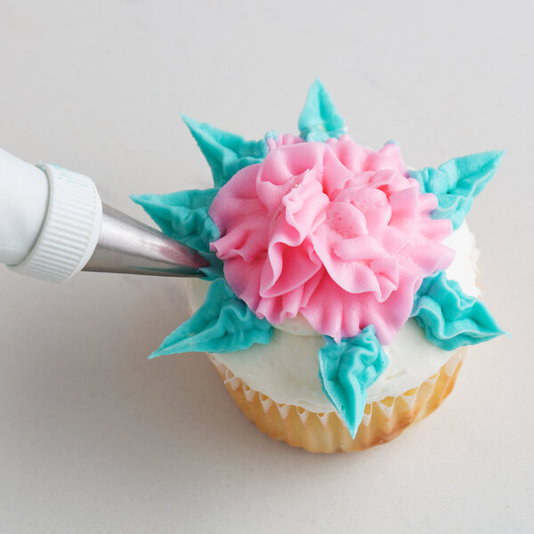 A cupcake with blue and white frosting decorated with a flower using an Ateco Leaf piping tip.