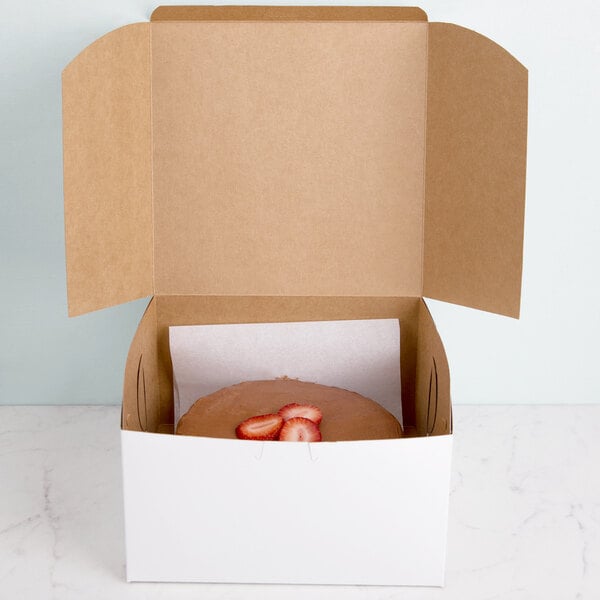 A 9" x 9" x 5" white cake box with a strawberry inside.