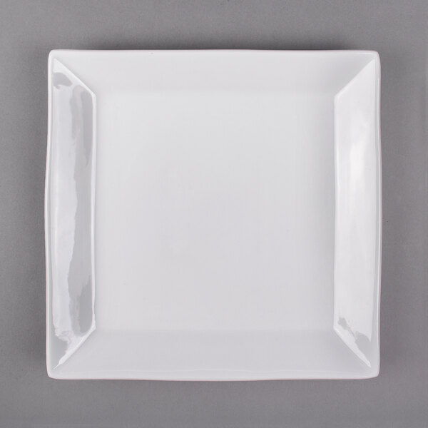 A white square plate with a black and silver rim.