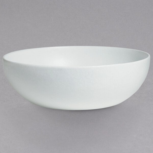 A white G.E.T. Enterprises Bugambilia deep round bowl on a gray background.