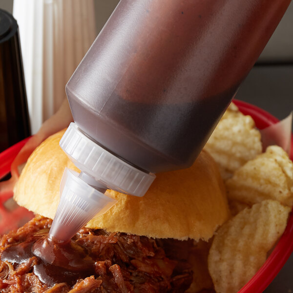 A close up of a Vollrath clear squeeze bottle with sauce on a burger.
