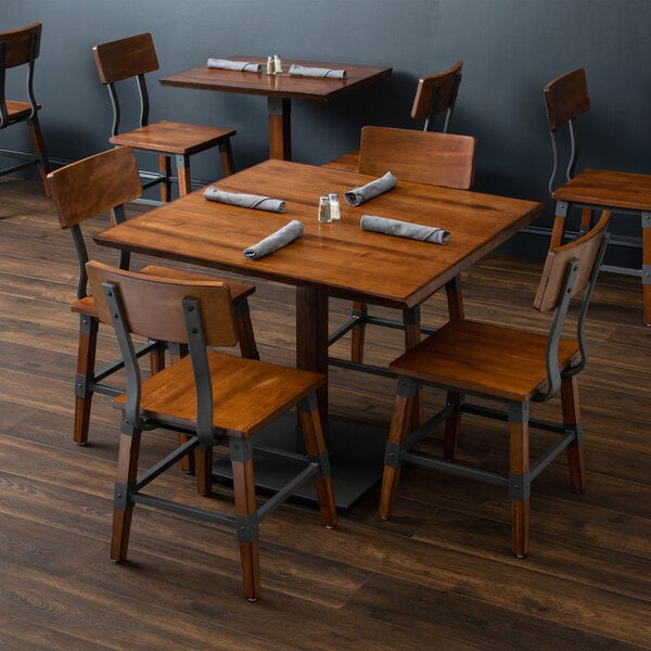 A Lancaster Table & Seating wooden table with chairs in a restaurant.