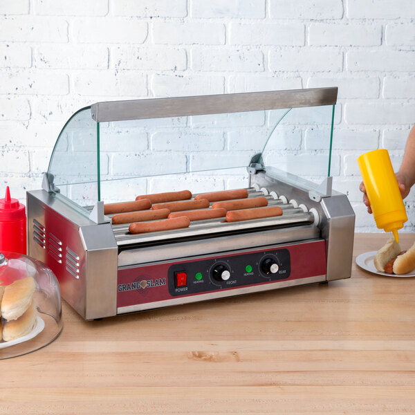 A hot dog being served on a Grand Slam hot dog roller grill on a counter.