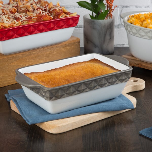 A Tuxton rectangular black and white casserole dish with pasta and sauce.