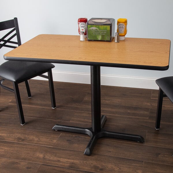 A Lancaster Table & Seating table with a reversible walnut and oak top and a cross base plate.