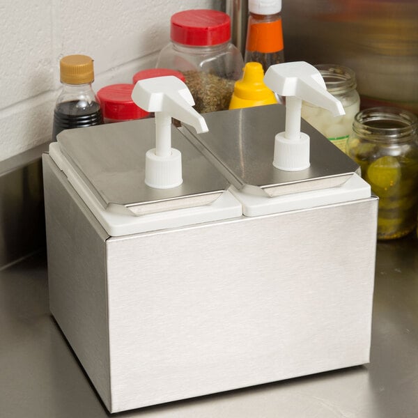 A metal Carlisle condiment rail with two white plastic dispensers on top.
