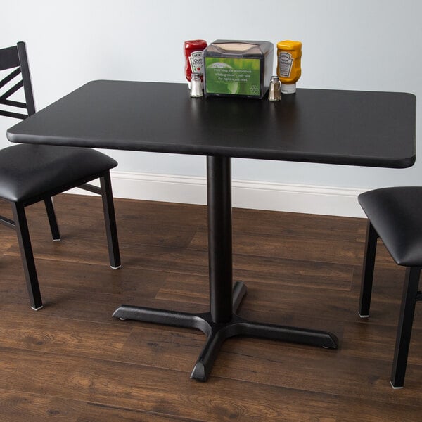 A black table with a cherry table top and a cross base plate.