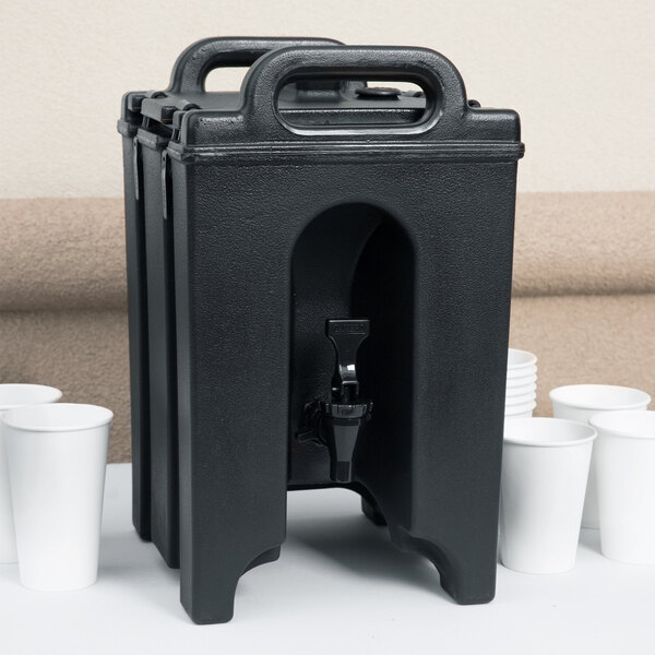 A black Cambro insulated beverage dispenser with a spigot and white cups.