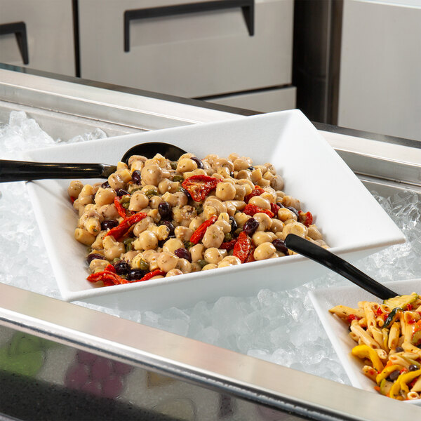 A white G.E.T. Enterprises Bugambilia resin-coated aluminum deep square bowl of food on a counter in a salad bar.