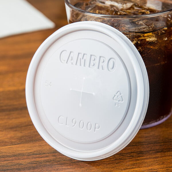 A Cambro translucent plastic lid on a glass of liquid with a straw.