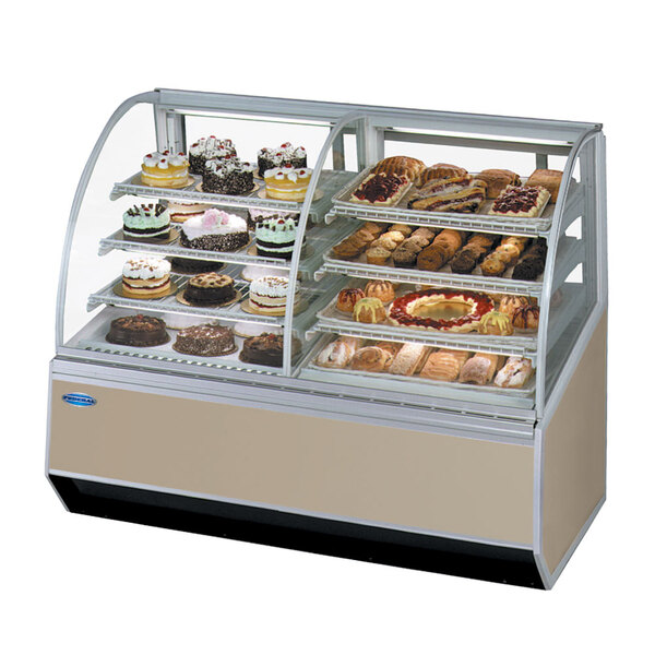 A Federal Industries Series '90 refrigerated bakery case with dual curved glass on a counter with different types of pastries.