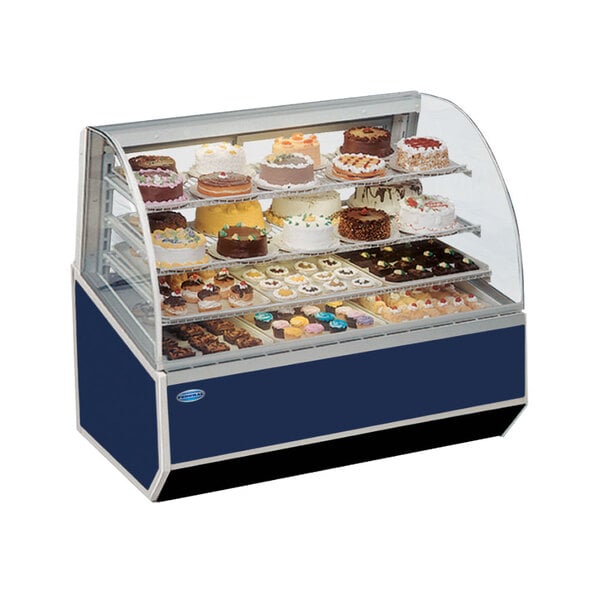 A Federal Industries Series '90 double-curved glass refrigerated bakery case displaying cakes.