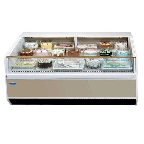 A Federal Industries SN-4CD-SS Series '90 self-serve refrigerated bakery/deli case on a counter with cakes in it.