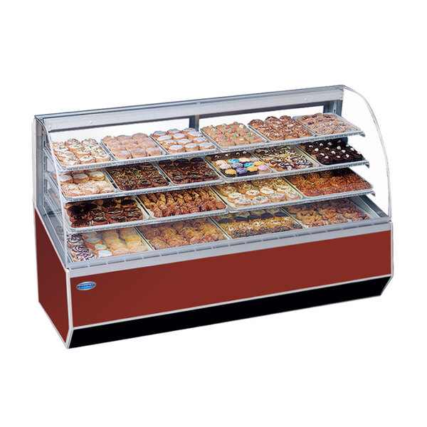 A Federal Industries Series '90 double-curved glass dry bakery case on a bakery counter filled with various pastries.
