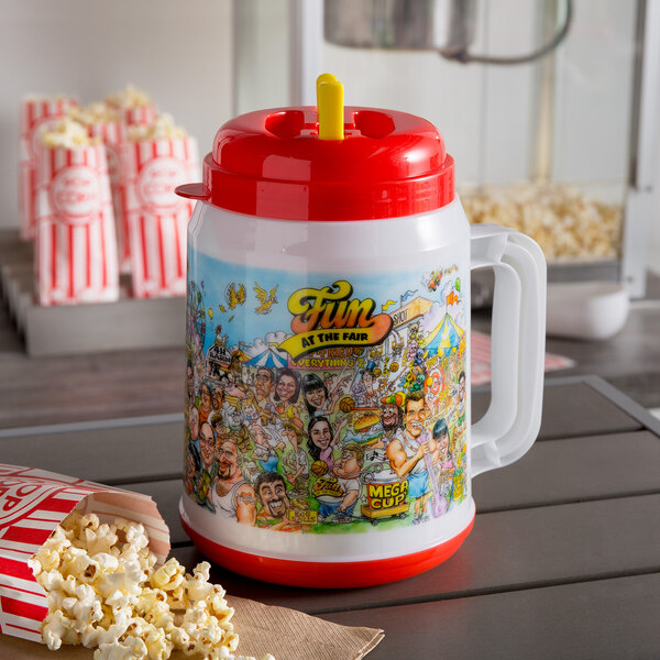 A "Fun at the Fair" plastic cup with a red lid and straw next to popcorn in a red and white striped container.