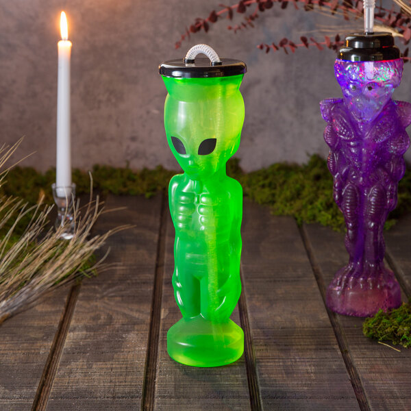 A green alien shaped bottle with a lid and straw.