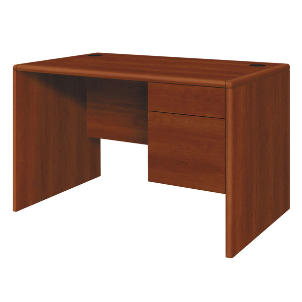 A wooden HON 10700 Series single pedestal desk with two drawers in cognac wood finish.