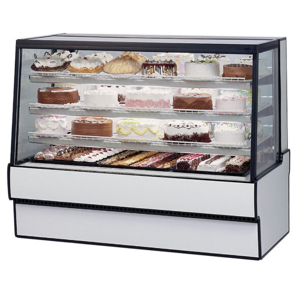 A Federal Industries dry bakery display case with cakes on it.