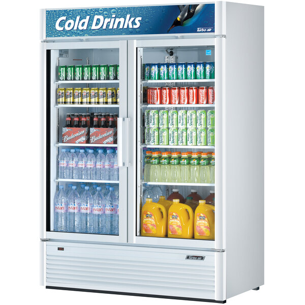 A white Turbo Air refrigerated merchandiser with bottles of soda and cans inside.