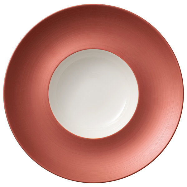 A white porcelain deep plate with a copper rim.