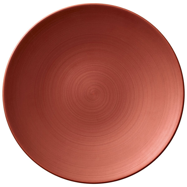 A close-up of a Villeroy & Boch Copper Glow porcelain plate with a red spiral pattern.