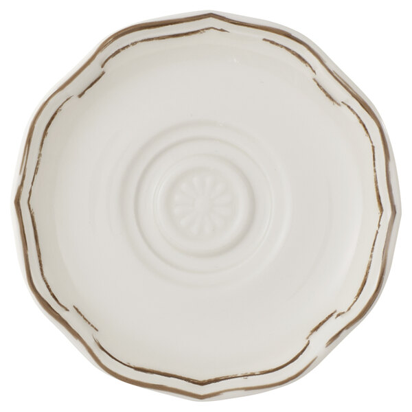 A close-up of a white Villeroy & Boch porcelain saucer with gold trim.