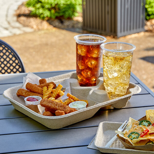 An EcoChoice molded pulp 2-cup carrier with large tray holding a glass of iced tea and a bowl of nachos on a table.