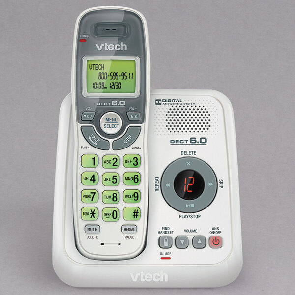 A white Vtech cordless phone with a green display.
