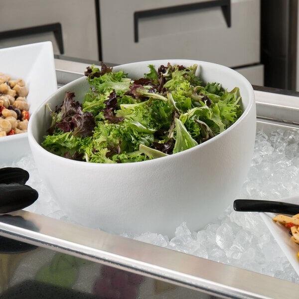 A G.E.T. Enterprises white resin-coated aluminum Texas round bowl with salad on ice.