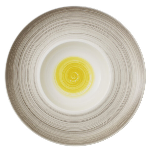 A white porcelain deep plate with a yellow swirl in it.