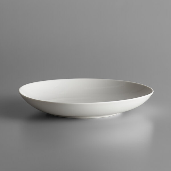 A Schonwald white porcelain deep coupe bowl on a grey surface.