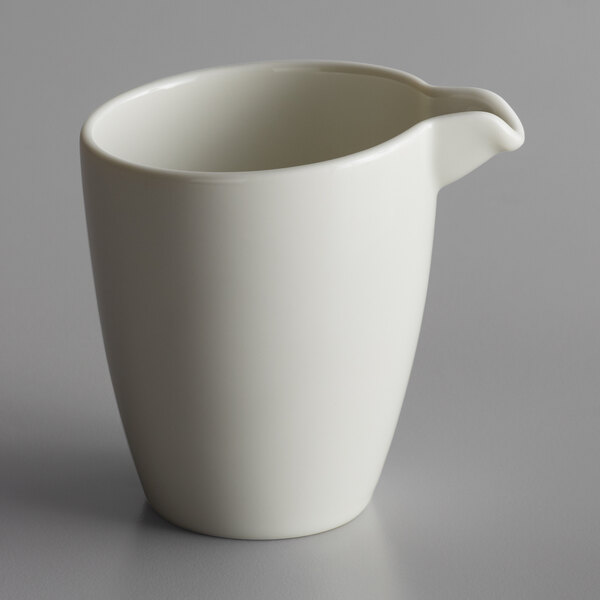 A white Schonwald porcelain creamer with a handle.
