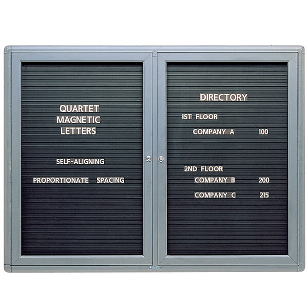 A white Quartet metal bulletin board with two doors.