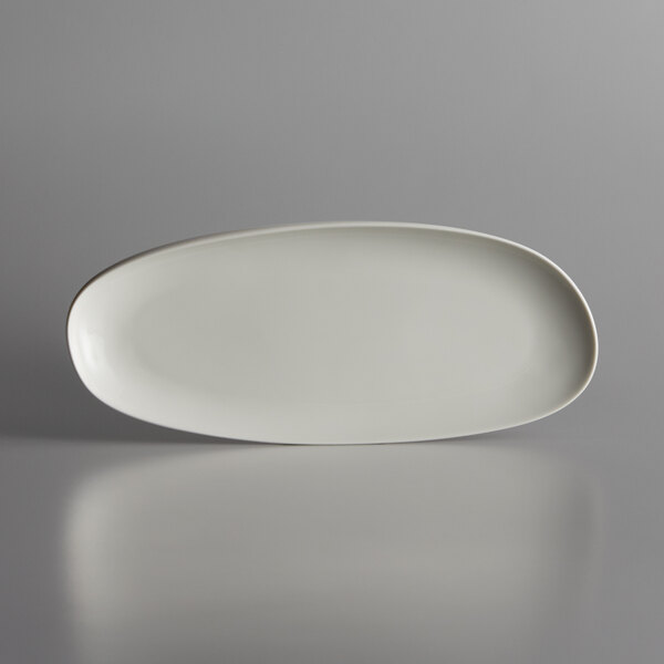 A white Schonwald oval porcelain tray with curved edges on a gray surface.
