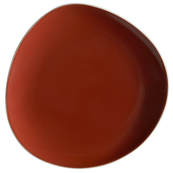 A close-up of a Schonwald red porcelain plate with a white border.