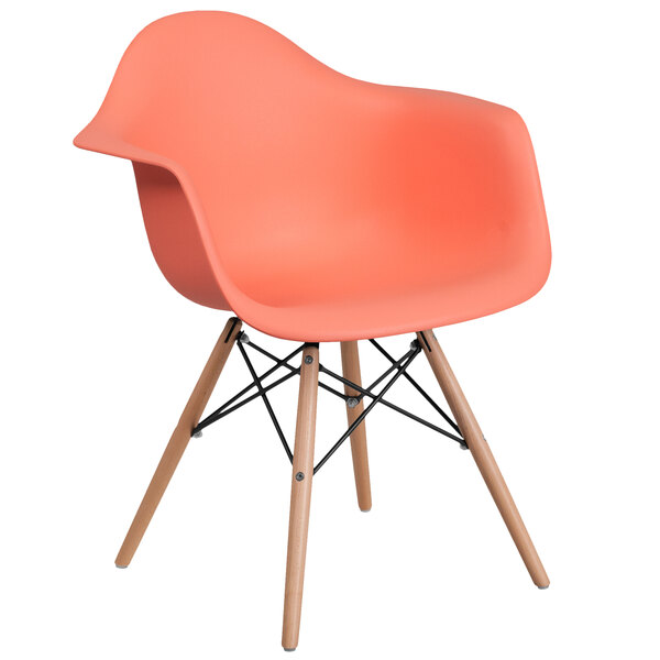A peach Flash Furniture plastic chair with wooden legs.