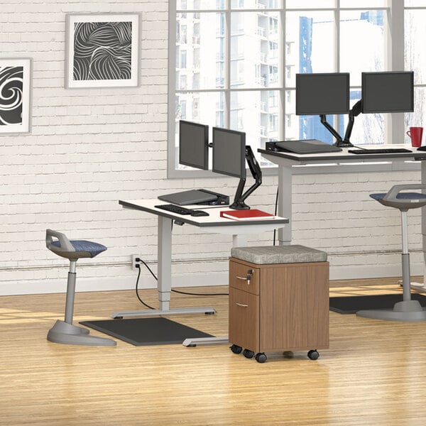 A desk with a white and grey rectangular Alera table top on metal legs with computers and stools.