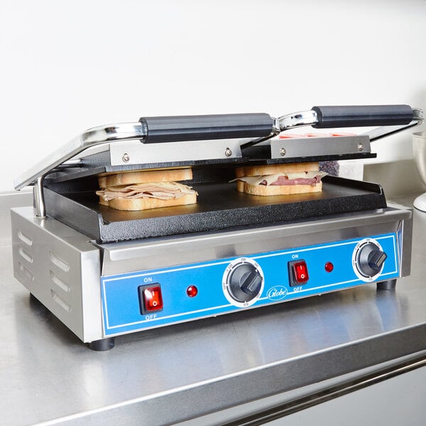 A Globe Bistro Series double sandwich grill with sandwiches on it.