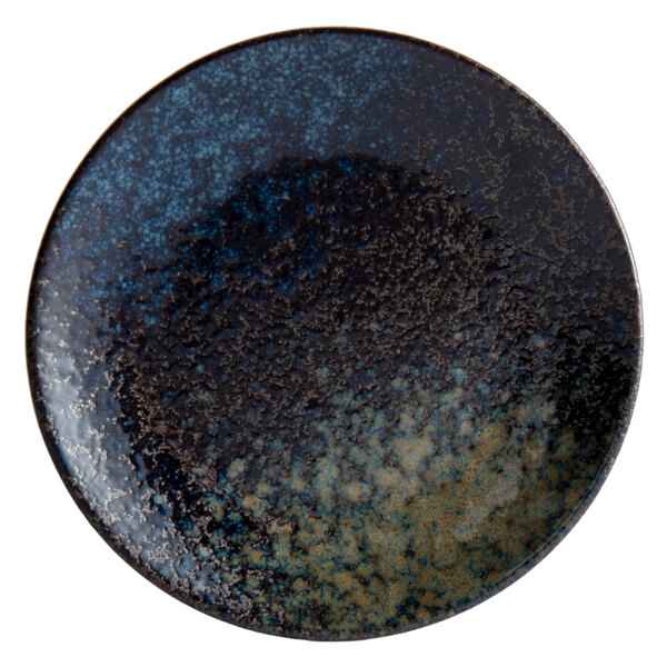 A close-up of a Playground sea blue and black speckled stoneware plate.