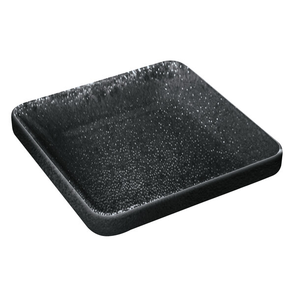A Playground Nara black square bowl filled with water on a counter.