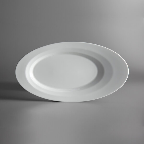 A Schonwald bone white oval porcelain platter on a gray surface.