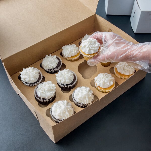A hand holds a Kraft cupcake in a 14" x 10" x 4" cupcake box.